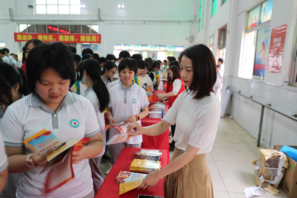 5.志愿者在华侨中学向学生发放宣传小册子.jpg