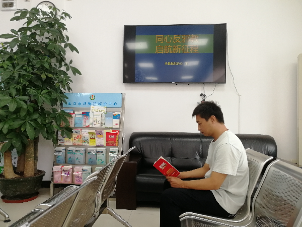 1.2综治中心办事群众在阅读宣传手册.jpg