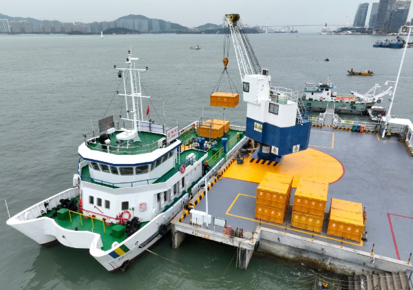 2024年1月25日，工作人员在厦门西堤海上环卫码头吊运海漂垃圾（无人机照片）。新华社记者 林善传 摄