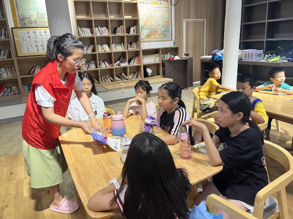 02.“百千万工程”突击队的小姐姐向村里的孩子们介绍反邪教宣传册上的内容.png